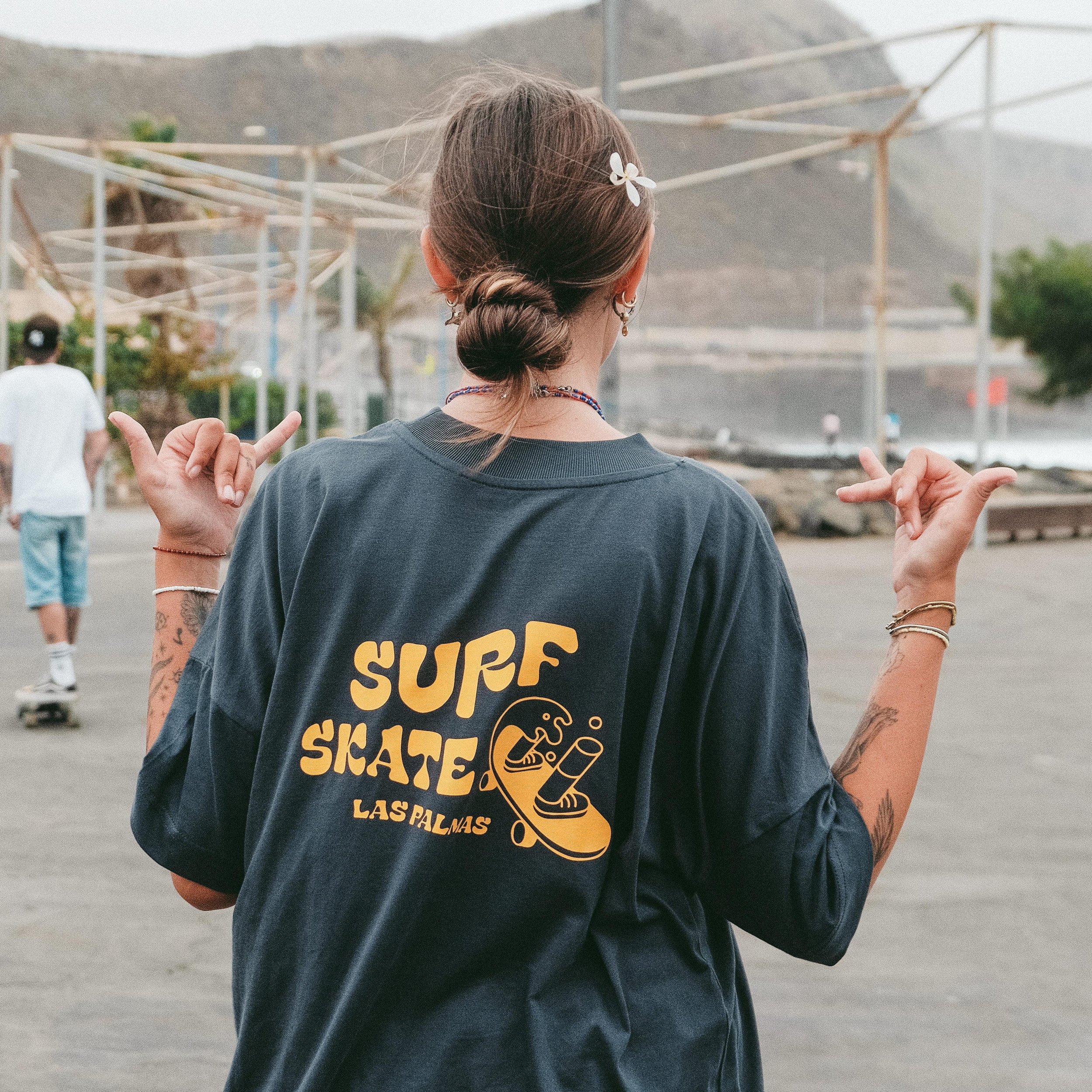 A girl wearing the surfskate las palmas merch tshirt at the skatepark.