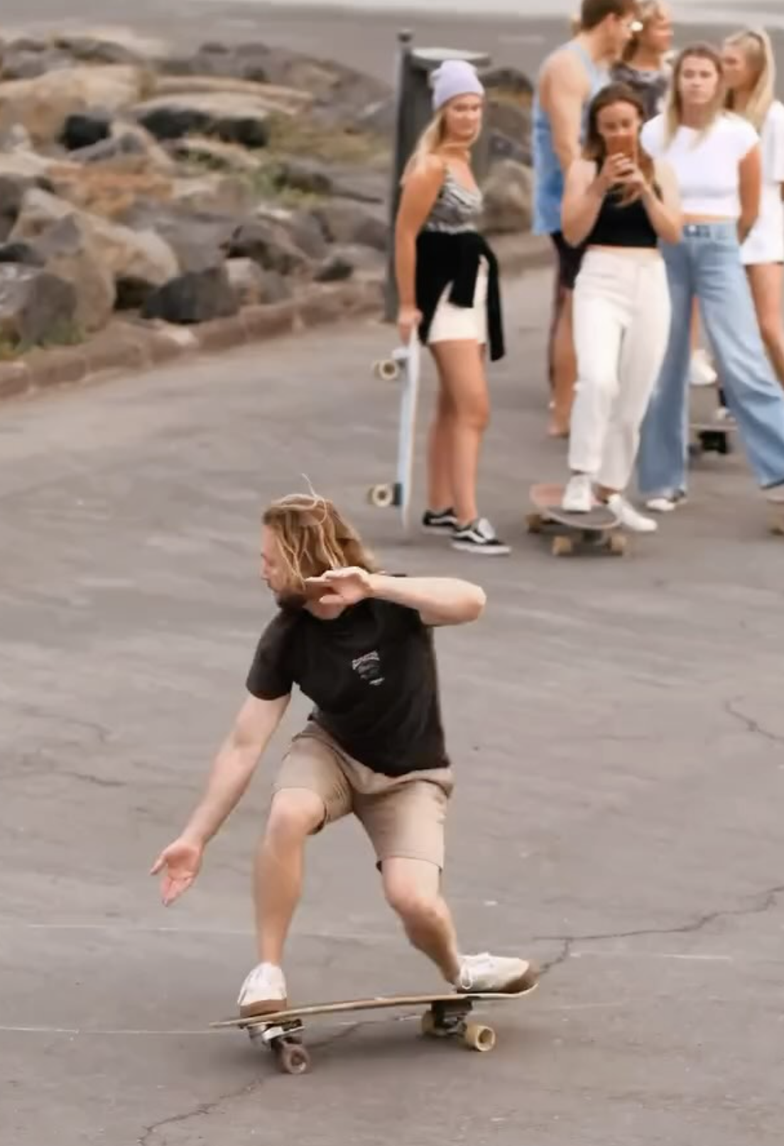 A teacher of surfskate las palmas, showing a group of people how to do the correct surf movements on the skate.